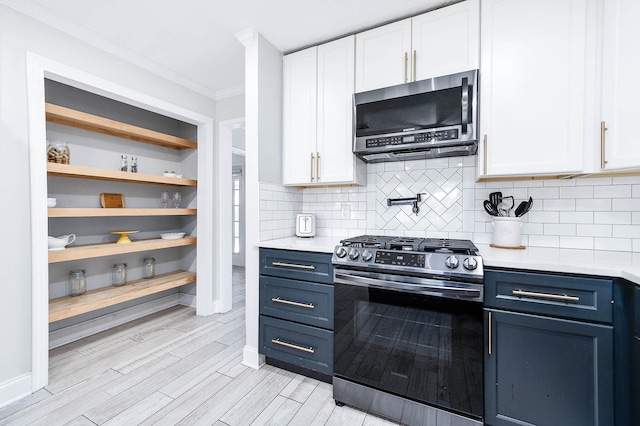 kitchen featuring crown molding, stainless steel appliances, white cabinets, and blue cabinets