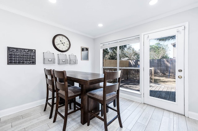 dining space with crown molding and light wood-type flooring