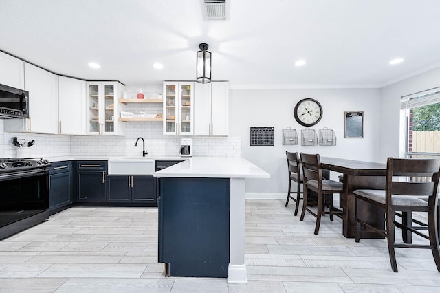 kitchen with white cabinets, kitchen peninsula, hanging light fixtures, and stove