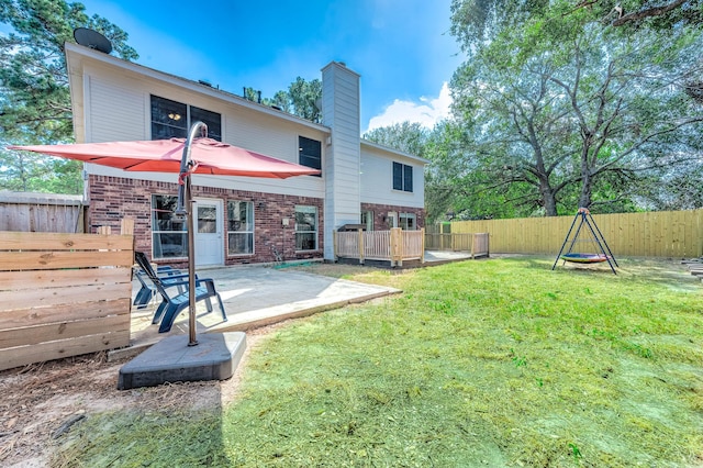 rear view of house featuring a lawn and a patio