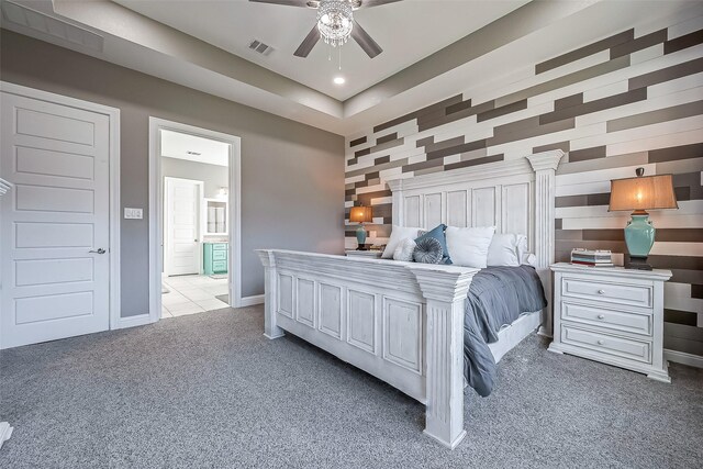 bedroom with light carpet, ensuite bath, and ceiling fan