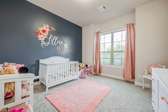 carpeted bedroom with a nursery area