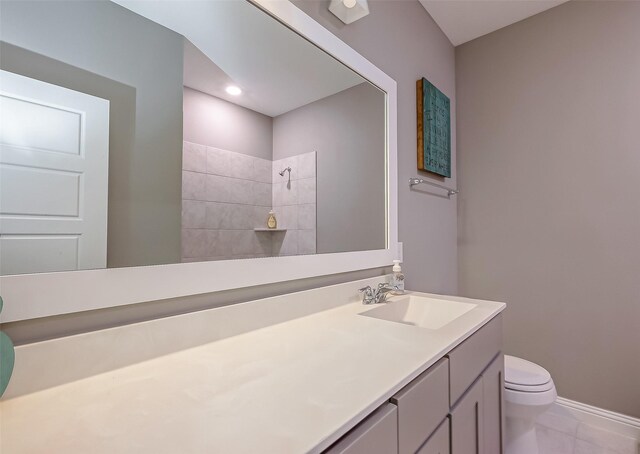 bathroom featuring tile patterned flooring, vanity, a shower, and toilet