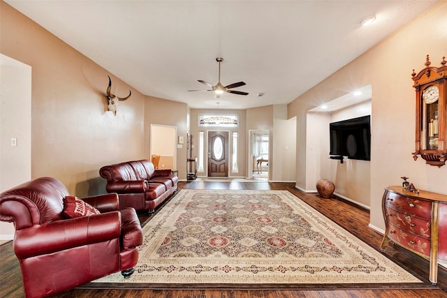 living room with dark wood-type flooring and ceiling fan