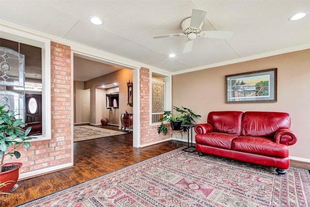 living room with ornamental molding, ceiling fan, and dark hardwood / wood-style flooring