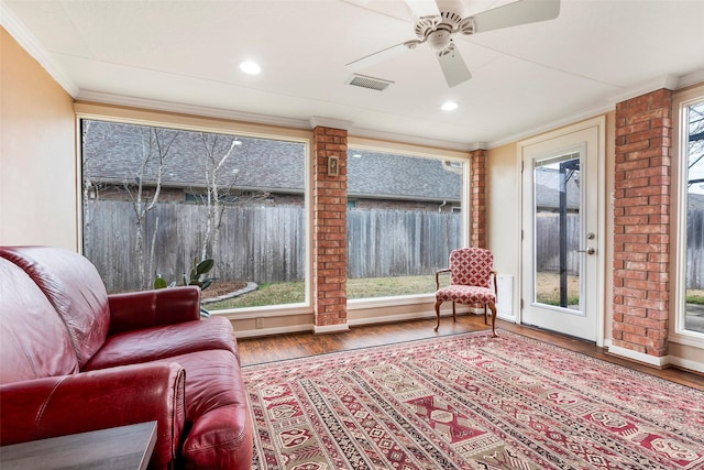 interior space with hardwood / wood-style flooring, ornamental molding, and ceiling fan