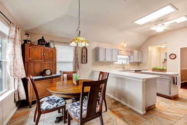 dining room featuring ceiling fan, plenty of natural light, sink, and vaulted ceiling