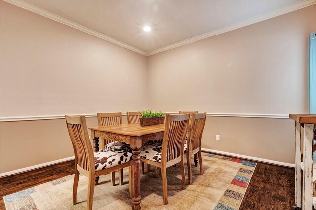 dining space with crown molding and hardwood / wood-style floors