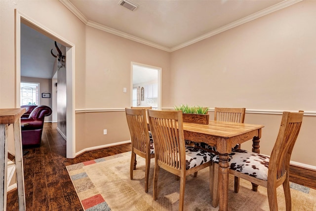 dining space with crown molding and dark hardwood / wood-style flooring