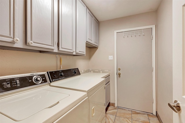 laundry room featuring cabinets, washing machine and dryer, and light tile patterned floors