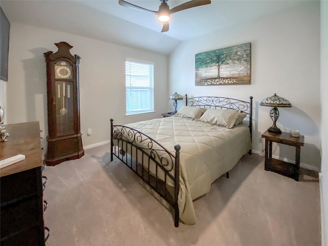 bedroom featuring a ceiling fan, vaulted ceiling, light colored carpet, and baseboards