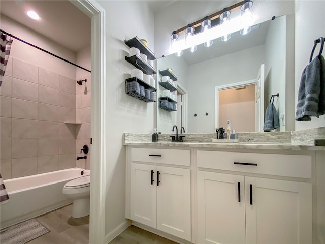 bathroom with toilet, vanity, bathtub / shower combination, and wood finished floors