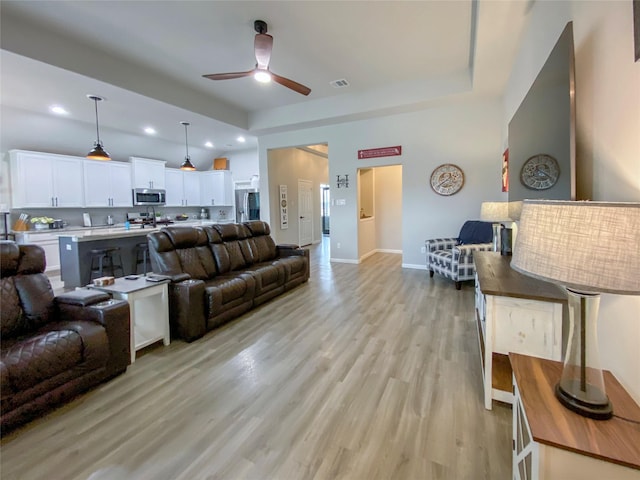 living area featuring baseboards, visible vents, recessed lighting, ceiling fan, and light wood-type flooring