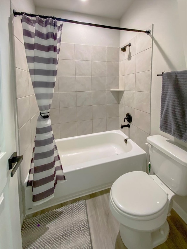 full bath featuring toilet, shower / bath combo with shower curtain, and wood finished floors