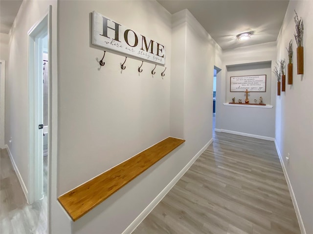 corridor with baseboards and wood finished floors