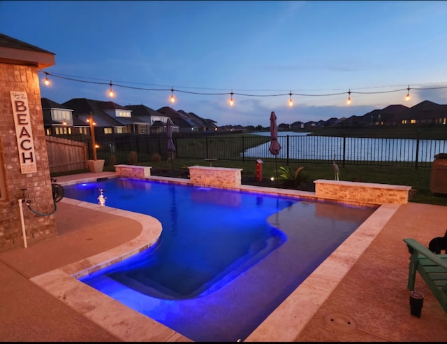 pool at dusk with a patio area, a fenced in pool, and a fenced backyard