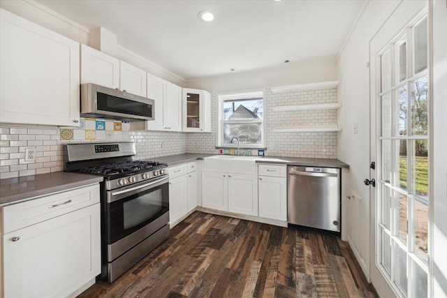 kitchen with appliances with stainless steel finishes, dark hardwood / wood-style floors, tasteful backsplash, sink, and white cabinets