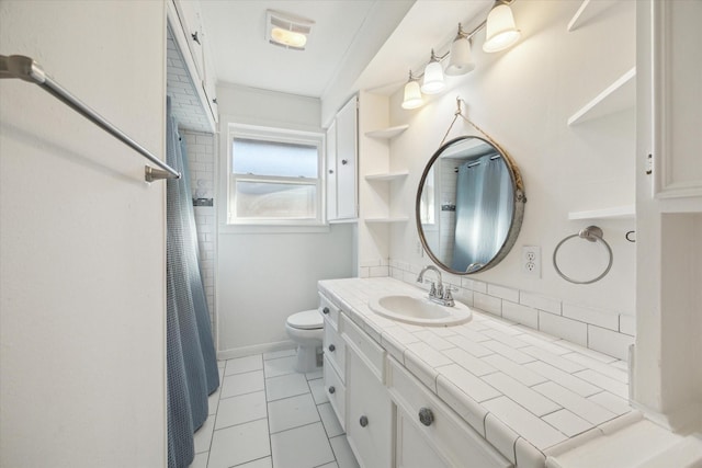 bathroom featuring tile patterned flooring, vanity, crown molding, and toilet