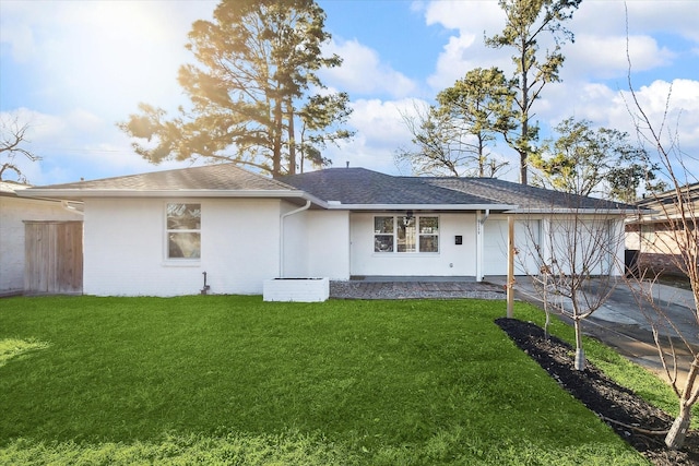 rear view of house featuring a lawn