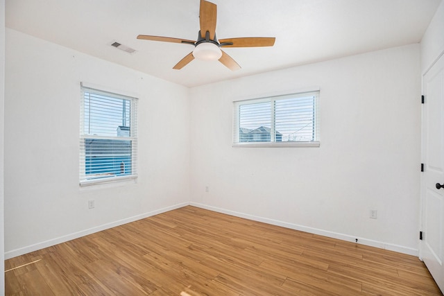 spare room with plenty of natural light, light hardwood / wood-style floors, and ceiling fan