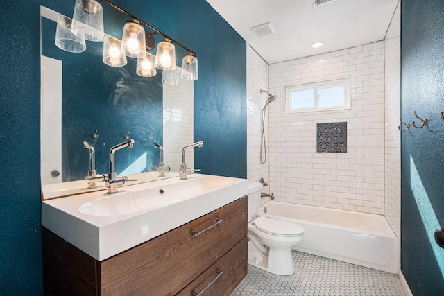 full bathroom featuring tiled shower / bath combo, vanity, tile patterned floors, and toilet