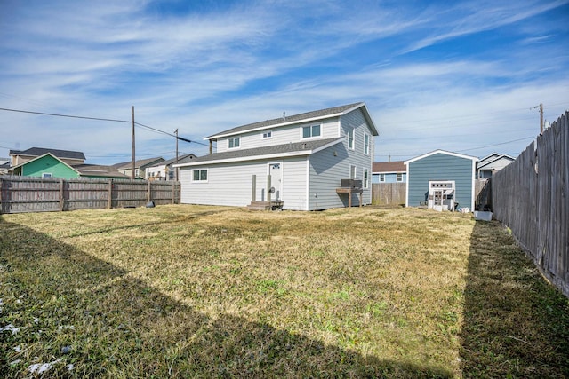 back of house with a yard, an outbuilding, and cooling unit