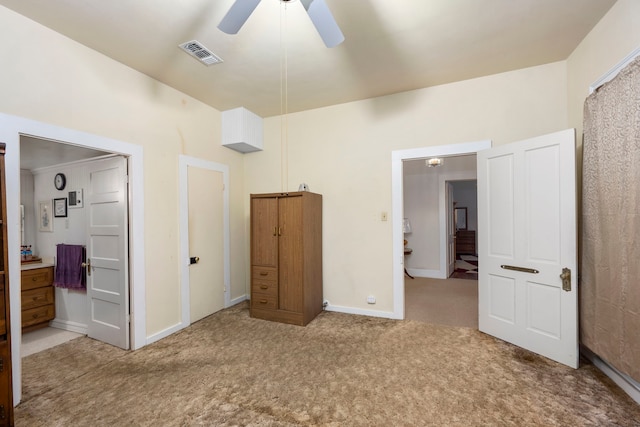 unfurnished bedroom with ceiling fan, ensuite bathroom, and carpet flooring