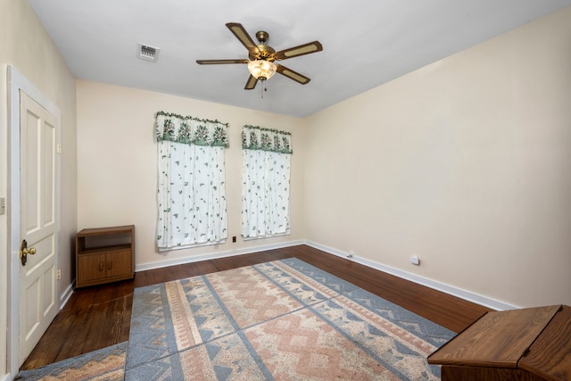 empty room with dark hardwood / wood-style flooring and ceiling fan