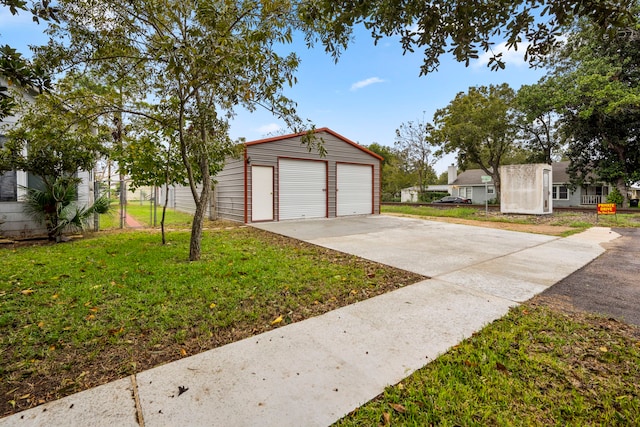 exterior space featuring an outbuilding, a garage, and a front yard