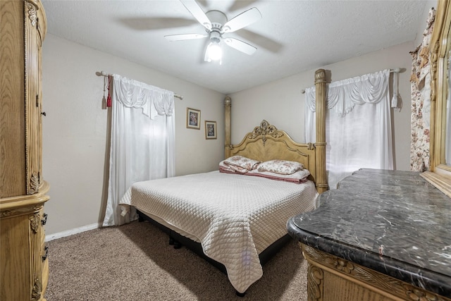 bedroom with ceiling fan, carpet floors, and a textured ceiling