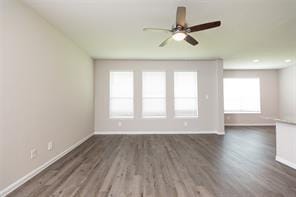 unfurnished room with dark wood-type flooring and ceiling fan