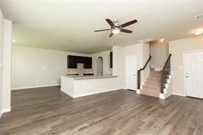 unfurnished living room with dark hardwood / wood-style flooring and ceiling fan