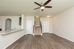 unfurnished living room featuring dark wood-type flooring and ceiling fan