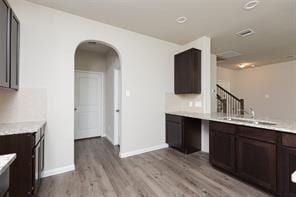 kitchen with dark brown cabinets and light hardwood / wood-style floors