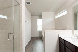 bathroom featuring vanity, hardwood / wood-style floors, and a shower with shower door