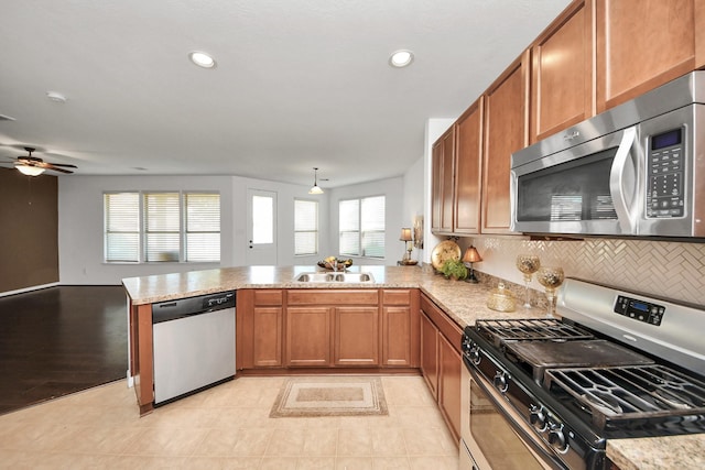 kitchen featuring tasteful backsplash, sink, stainless steel appliances, and kitchen peninsula