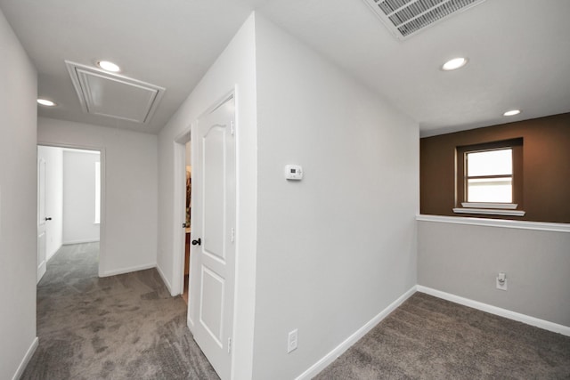 corridor featuring dark colored carpet