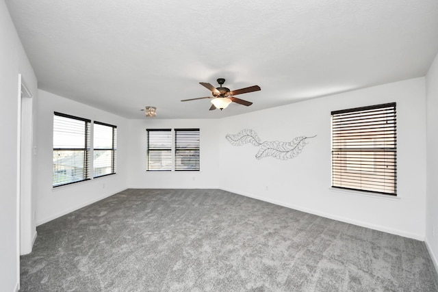 carpeted spare room featuring a textured ceiling and ceiling fan