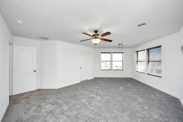 carpeted empty room with ceiling fan and a textured ceiling