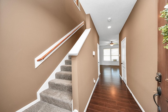 staircase with a skylight, wood-type flooring, and ceiling fan