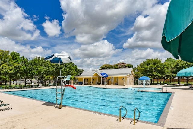 view of swimming pool featuring pool water feature and a patio area