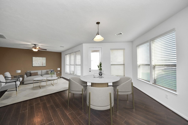 dining area featuring dark wood-type flooring and ceiling fan