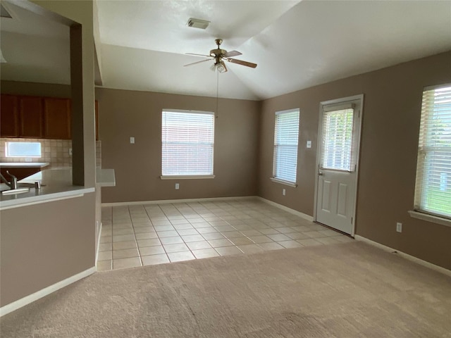 unfurnished living room with lofted ceiling, ceiling fan, and light tile patterned flooring