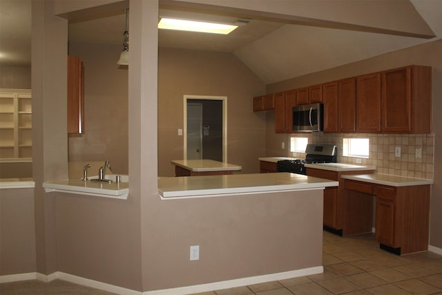 kitchen featuring stainless steel appliances, kitchen peninsula, decorative backsplash, and decorative light fixtures