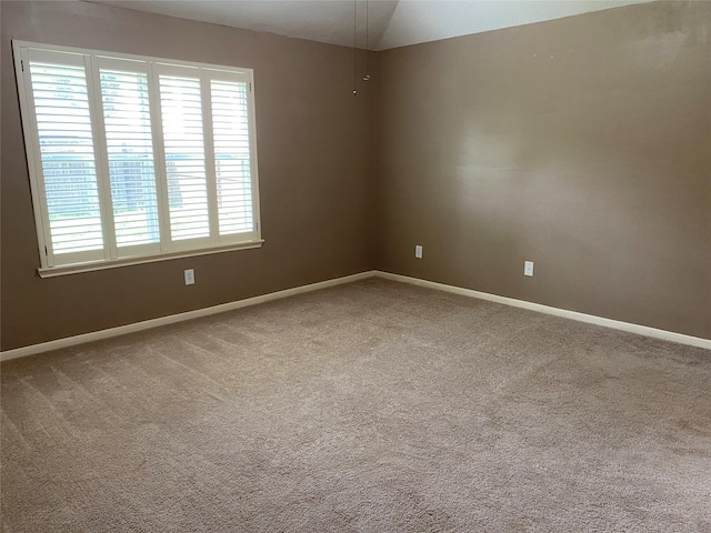 spare room with carpet and lofted ceiling