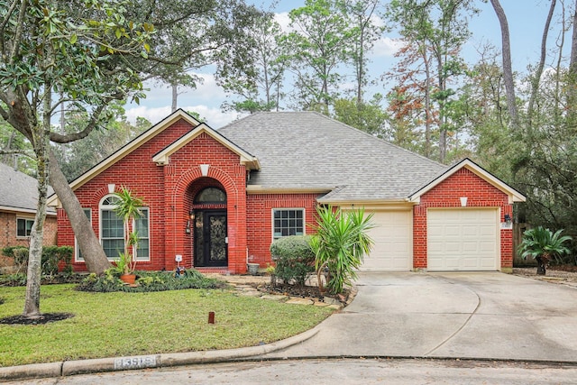 traditional-style house with brick siding, a shingled roof, a front lawn, driveway, and an attached garage