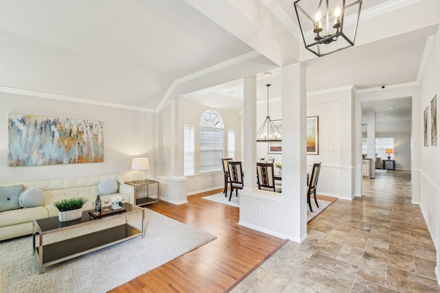 living area featuring a notable chandelier, wood finished floors, baseboards, and ornamental molding