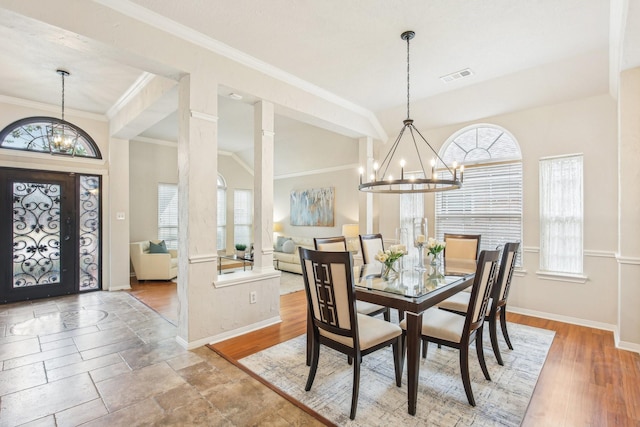 dining area with ornamental molding, decorative columns, and a chandelier