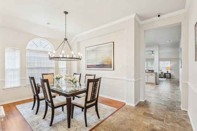 dining area featuring a notable chandelier, crown molding, a wealth of natural light, and wood-type flooring