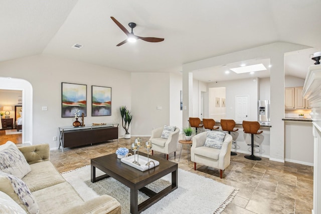 living area with a ceiling fan, baseboards, visible vents, lofted ceiling, and arched walkways